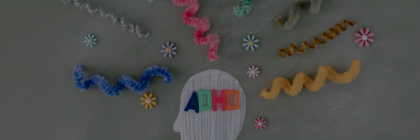ADHD is the text in the image. It represents Attention Deficit Hyperactivity Disorder. The image also includes colorful pipe cleaners, flowers, and other decorative elements to illustrate the concept of a busy or chaotic mind, often associated with ADHD.
