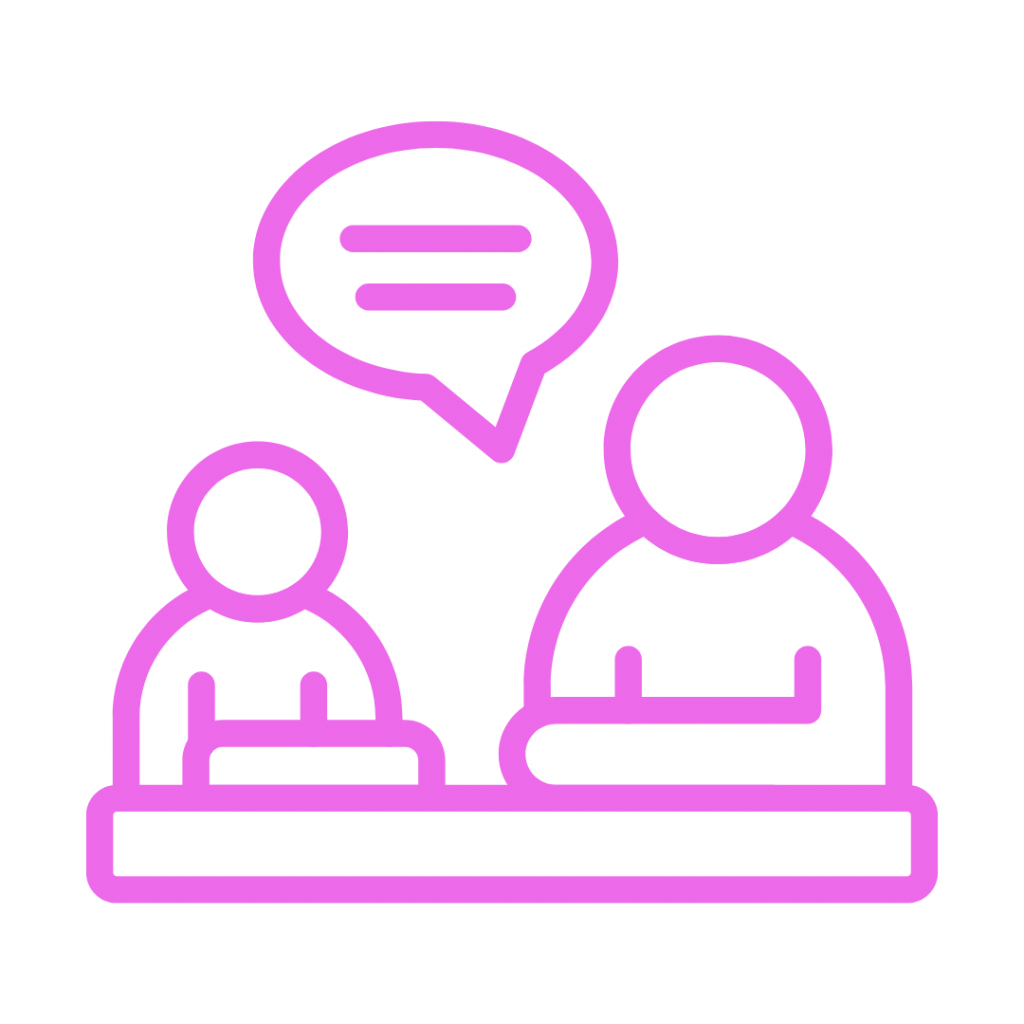 A vibrant pink outline icon showing two stylized figures seated across from each other at a table. A speech bubble with two horizontal lines, representing text or conversation, hovers above the figure on the right, suggesting a discussion, meeting, or therapy session.