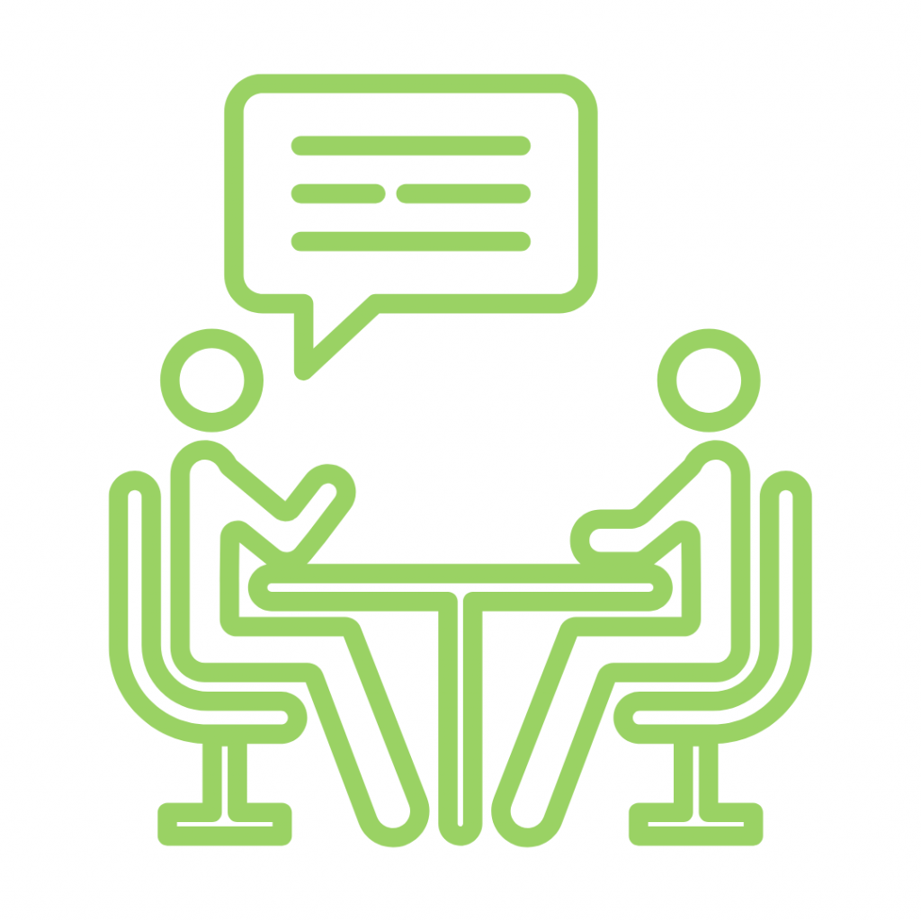 Green line drawing of two stick figures sitting across a table from each other, engaged in a conversation, meeting, or interview, with a chat bubble above them.