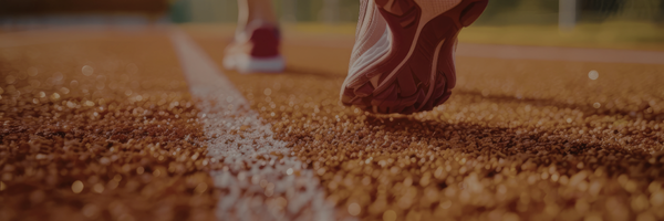 Close-up of a runner's shoe on a sunlit track.